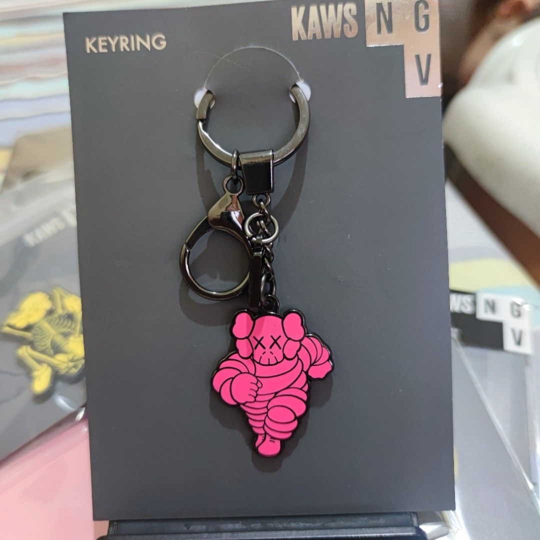 KAWS Pink Chum Keyring NGV Keychain (Category: Character Goods) located in Manila. Submitted by gochupsshop888 (Listing ID 1366829423, Image 1). Description: This keyring has been designed and made exclusively for the NGV design store in celebration of the exhibition KAWS: Companionship in the Age of Loneliness. Dimensions: 10cm x 10cm (backing card) Keyring is 4cm x 3.25cm Entire keyring length 11cm Keyring with additional lobster clasp Presente