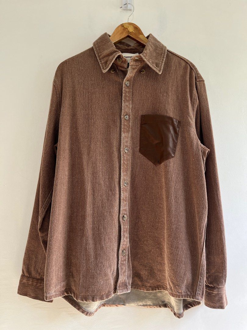 NANUSHKA Oversized Dome Denim Shirt (Category: Luxury Apparel) located in Dasmarinas. Submitted by bandananowheree (Listing ID 1366762127, Image 1). Description: Long sleeve non-stretch linen denim shirt in brown. Fading throughout. Buttoned spread collar. Button closure at front. Grained faux-leather patch pocket at chest. Shirttail hem. Two-button barrel cuffs. Tortoiseshell hardware..