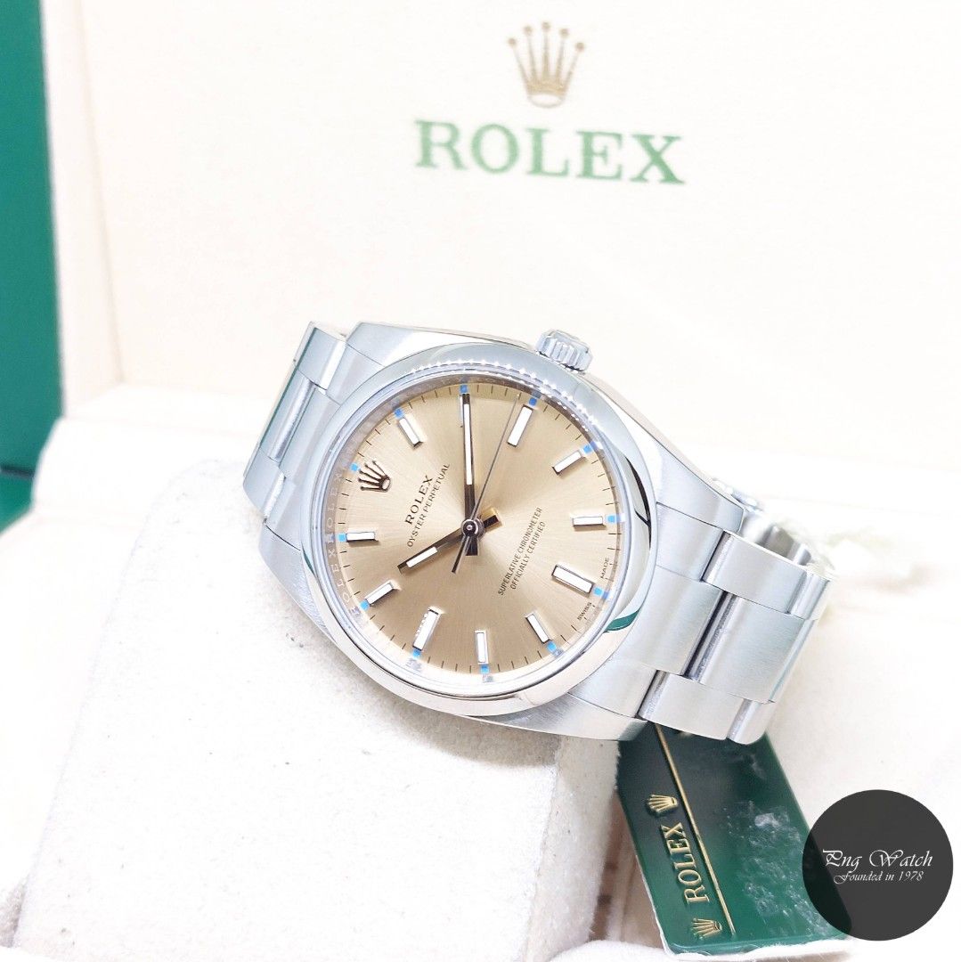 Rolex 34mm Champagne Batons Dial Oyster Perpetual REF: 114200 (Box, Card, Tag-2015) (Category: Watches) located in Singapore. Submitted by pngwatchdealer (Listing ID 1370404819, Image 1). Description: [SPECIFICATIONS] **Watch comes in full option (Box, Card & Tag)** **Straight bracelet** Brand: Rolex Model: Oyster Perpetual (REF: 114200)(AN)(15)(O) Movement: Automatic (Self-Winding) Functions and Features: Hours, Minutes and Seconds (CASE) Case M
