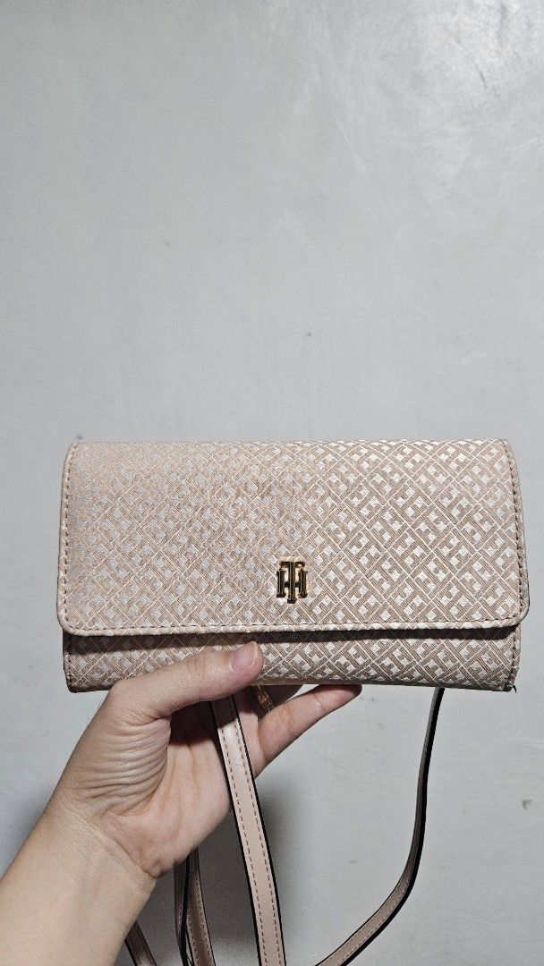 Tommy Hilfiger Phone wallet crossbody (Category: Wallets & Card holders) located in Valenzuela. Submitted by empot08 (Listing ID 1370772829, Image 1). Description: 100% OG flaw at the last picture - but barely noticeable still in good shape - color may vary in picture, looks dirty but its guaranteed clean.