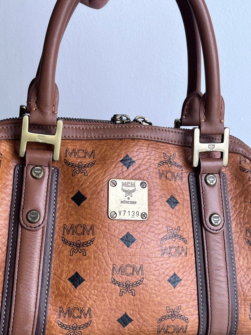 MCM Visetos Alma Cognac Boston Bag (Category: Luxury Bags & Wallets) located in Taguig. Submitted by mhalet.902 (Listing ID 1371624742, Image 2). Description: Gender: Ladies’ Material: Coated canvas Stamp: 1011077020122 Interior: One zip pocket and two open pockets Measurements: 11.6”L X 5.25”W X 7”H Handle Drop: 4.75” Hardware: Gold tone Inclusions: Luxe In dust bag Detailed Item Description: The item has scuff marks and discoloration on the pip
