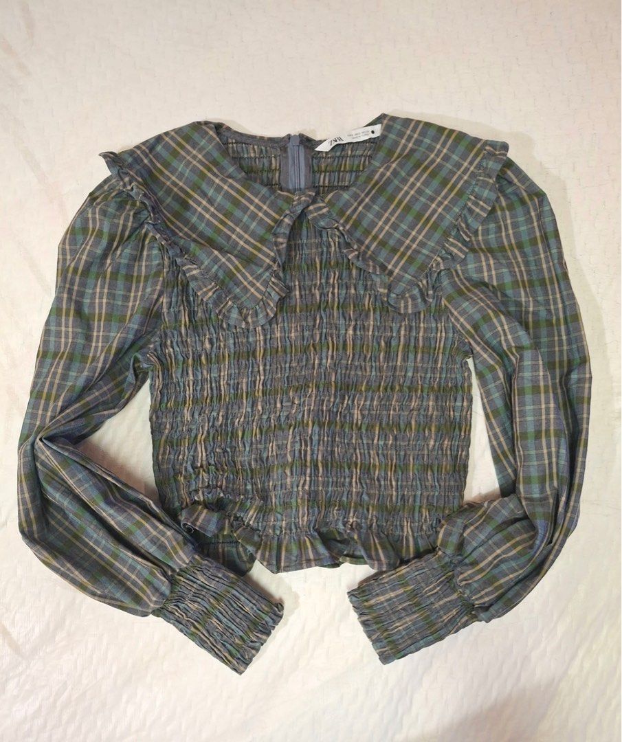 Zara Checkered Pattern Frill Collar Blouse (Category: Blouses) located in Makati City. Submitted by sweetsj (Listing ID 1371854561, Image 2). Description: It features a ruffled collar, long sleeves with smocked cuffs, and a smocked bodice 10/10 condition. Size Small but fits up to medium Width: 14” but stretchable Length: 16”.