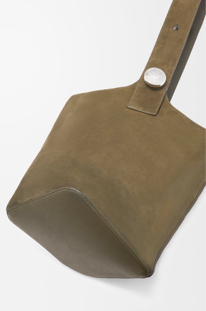 Loewe Large Pebble bucket bag in suede calfskin (Category: Bags & Wallets) located in Singapore. Submitted by danjhl (Listing ID 1367267398, Image 2). Description: Color Dark Olive. New season color! The Pebble is a minimalistic bucket bag with a wide strap adjustable through an oversized Pebble closure. This large version is crafted in suede calfskin with a smooth nappa reverse on the inside. Shoulder or crossbody carry One internal calfskin poc