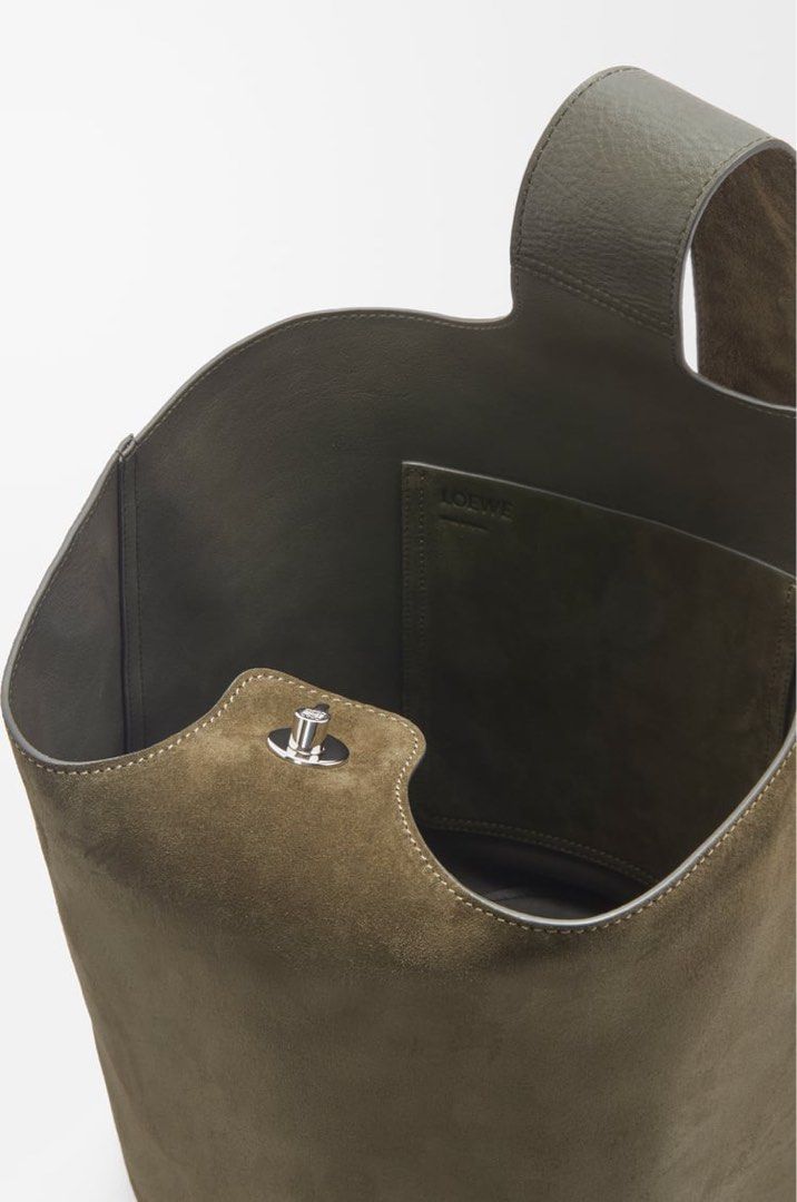 Loewe Large Pebble bucket bag in suede calfskin (Category: Bags & Wallets) located in Singapore. Submitted by danjhl (Listing ID 1367267398, Image 1). Description: Color Dark Olive. New season color! The Pebble is a minimalistic bucket bag with a wide strap adjustable through an oversized Pebble closure. This large version is crafted in suede calfskin with a smooth nappa reverse on the inside. Shoulder or crossbody carry One internal calfskin poc