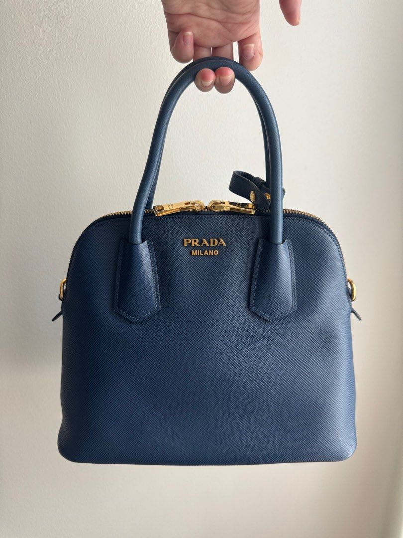 Pre-loved Prada Saffiano Cuir Dome Bag with strap (Category: Luxury Bags & Wallets) located in Pasig City. Submitted by curatedcoph (Listing ID 1367183066, Image 1). Description: Almost new With authenticity card, care card & receipt from Prada Boutique, Greenbelt Bought for P104,000 From my personal collection.
