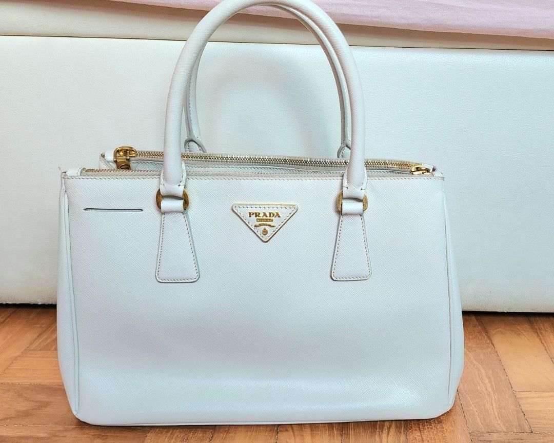 Authentic Prada Saffiano Leather Bag, Medium, Top Handle Bag (Category: Bags & Wallets) located in Singapore. Submitted by j-dpose (Listing ID 1367387218, Image 1). Description: Elevate your style with this preloved Authentic Prada Saffiano Leather Bag in medium size—a timeless classic that’s perfect for any occasion! Crafted from luxurious Saffiano leather, this top handle bag exudes elegance and durability. Its spacious interior and structured 