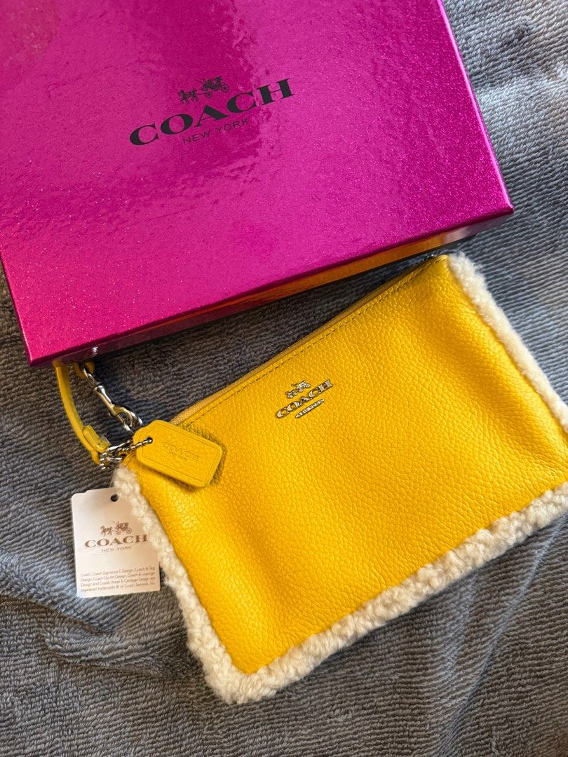 Coach Shearling and Pebbled Small Wristlet (Category: Luxury Bags & Wallets) located in Pasay City. Submitted by andreaflo (Listing ID 1367327822, Image 1). Description: • Color: Yellow/Banana 🍌 • Condition: new with tag, care instructions, & box • Super ✨cutesy✨ with faux fur trim • inside: w/ pockets for credit card .
