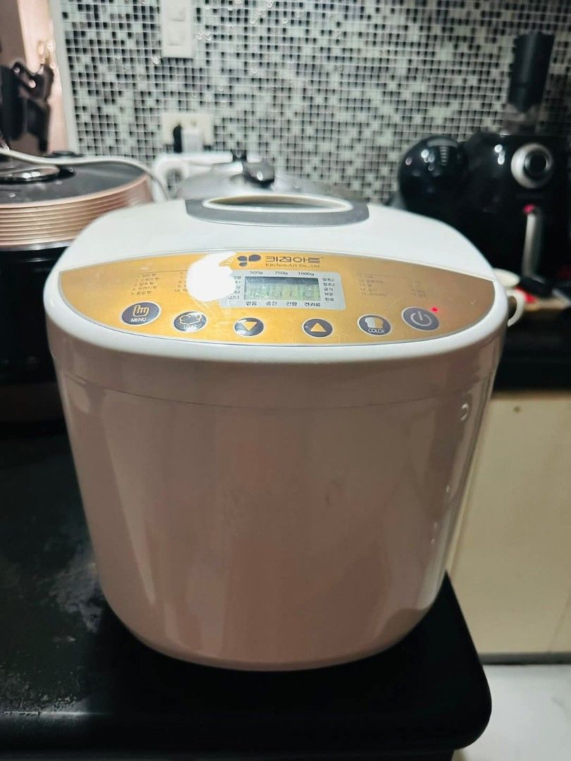 Dough and Breadmaker (Category: Breadmakers) located in Bulacan. Submitted by mysticdeer.6d7f47 (Listing ID 1367524817, Image 1). Description: The appliance in the image is a Kitchen Art bread maker, likely a model from the Korean brand. Here's some information about it: It is designed for home use to bake various types of bread. The control panel includes settings for different bread sizes (500g, 750g, 1000g) and functions. It likely has a timer