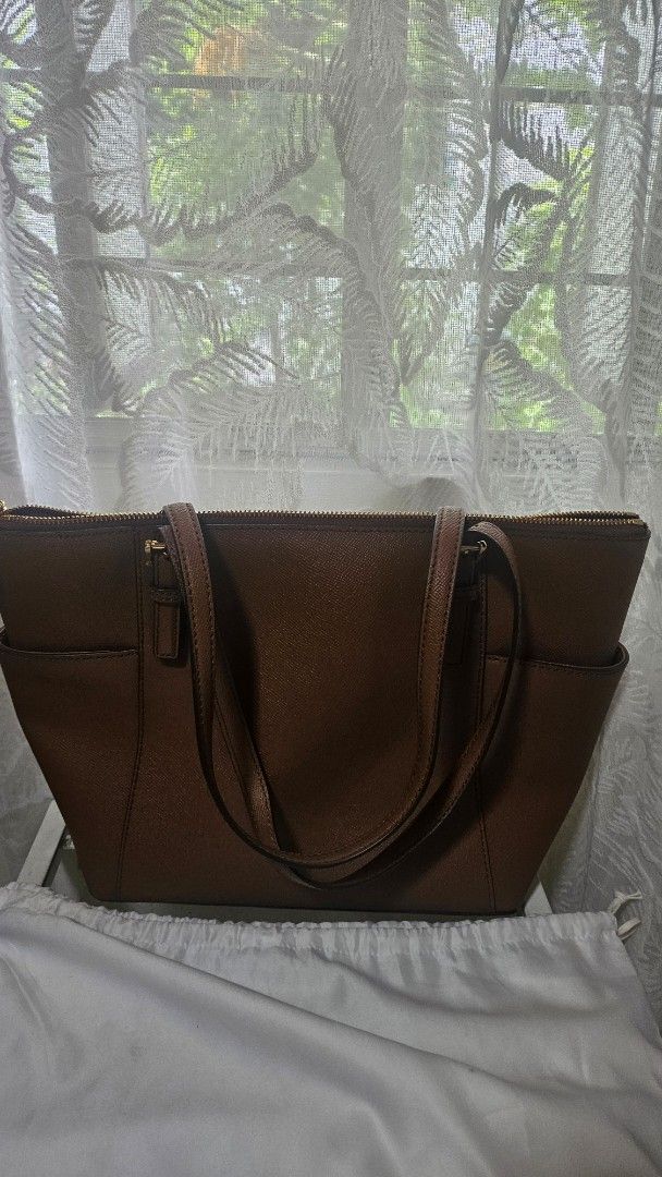 Original Michael Kors Charlotte Tote Bag (Category: Luxury Bags & Wallets) located in Pasig City. Submitted by thegarmentstale (Listing ID 1367714840, Image 2). Description: Original from UK with Tag Price Dust Bag Included Gold Toned Hardware Michael Kors Logo at Front 2 Slip-in Back Pocket On Side 1 MK Circle Charm Zip Top Closure Custom Fabric Lining 2 Slip-in Pockets 1 Zipped Pocket 15"(Top) 11"(Bottom) x 10"(H) x 4.5"(D) Straps: 9.5".