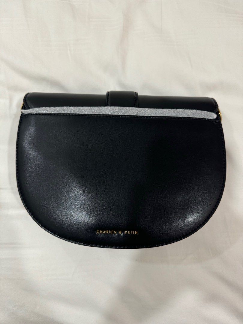 Charles and Keith Gabine Leather Saddle Bag in black (Category: Purses & Pouches) located in Singapore. Submitted by anyaparekhh (Listing ID 1374072711, Image 2). Description: Brand new Charles and Keith Gabine Leather Saddle Bag black and gold purse. Comes with long strap and dust bag. Retails for $170. .