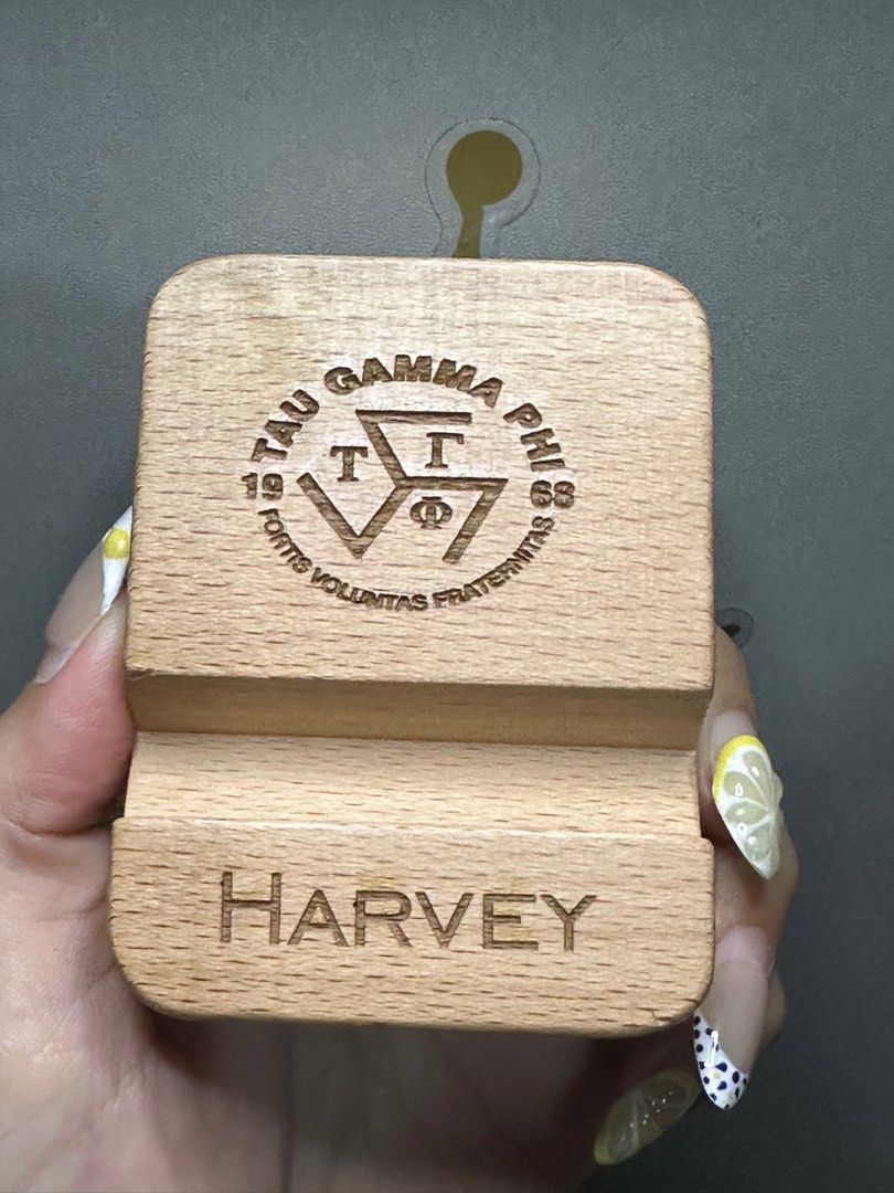 Phone stand with engraved logo & name (Category: Mounts & Holders) located in Manila. Submitted by harveybirosel (Listing ID 1374694901, Image 2). Description: Phone stand with engraved logo & name Beech wood - Sample pics shown iphone 14 & Samsung S24 Ultra.