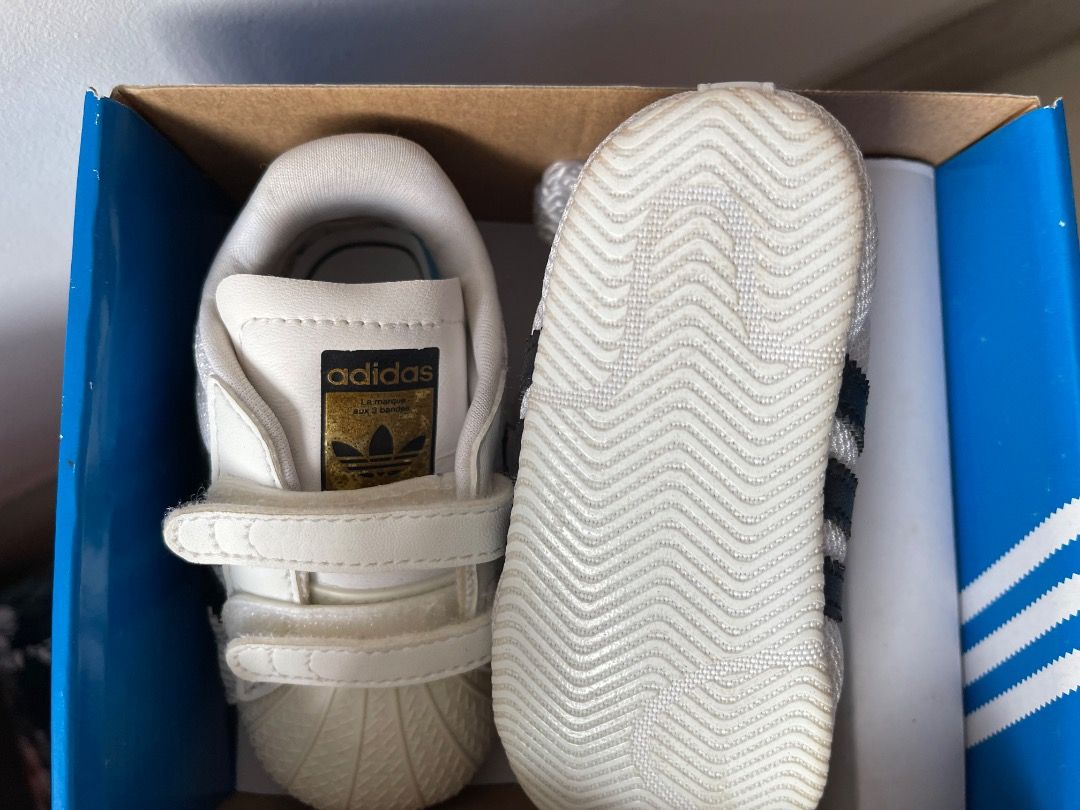Adidas Superstar Crib Shoes size 3K (Category: Babies & Kids Fashion) located in Singapore. Submitted by orangetart (Listing ID 1374900287, Image 3). Description: Mesh upper Hook-and-loop comfort closure for easy on and off; Anti-slip rubber toe cap Jersey lining Synthetic leather 3-Stripes Logo on synthetic leather heel patch Woven outsole with anti-slip rubber print Colour: Cloud White / Core Black / Cloud White.
