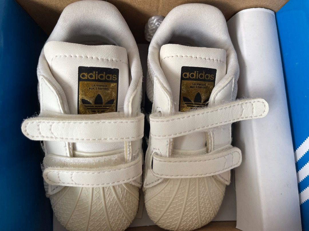 Adidas Superstar Crib Shoes size 3K (Category: Babies & Kids Fashion) located in Singapore. Submitted by orangetart (Listing ID 1374900287, Image 2). Description: Mesh upper Hook-and-loop comfort closure for easy on and off; Anti-slip rubber toe cap Jersey lining Synthetic leather 3-Stripes Logo on synthetic leather heel patch Woven outsole with anti-slip rubber print Colour: Cloud White / Core Black / Cloud White.