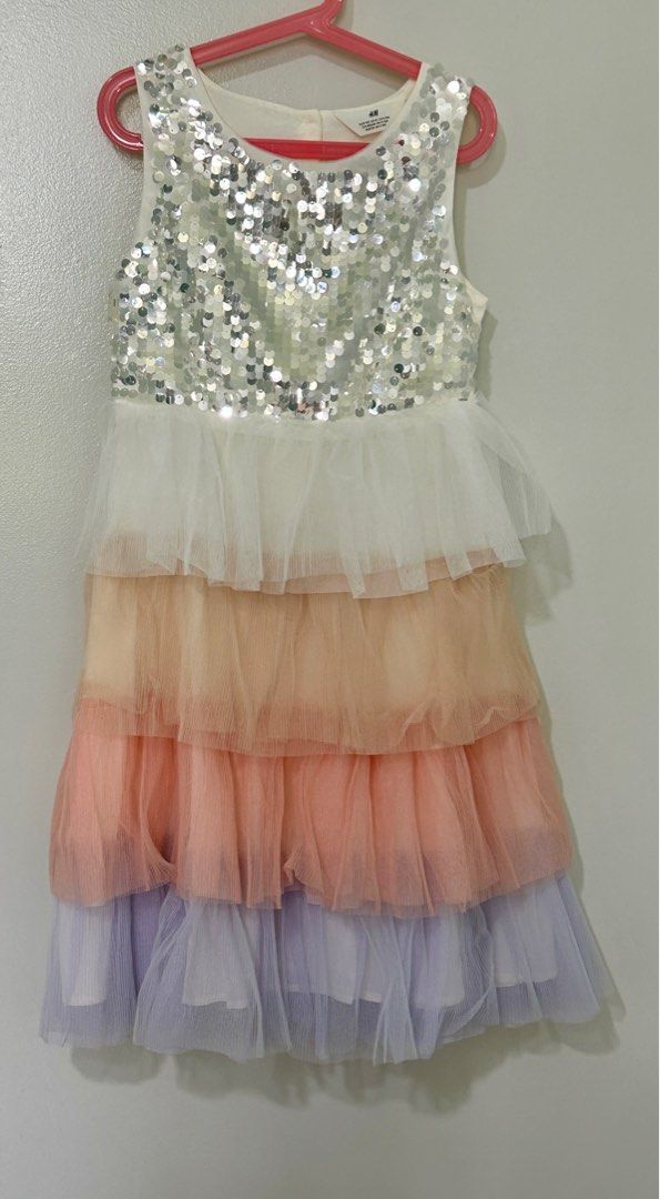 [Size 140cm] H&M Rainbow Ruffle Dress with Sequin Details (Category: Babies & Kids Fashion) located in Singapore. Submitted by nightjean7 (Listing ID 1375126379, Image 1). Description: Never worn, way too big for my girl. H&M kid sizing tends to be bigger than other brands. May be suitable for 120cm - 130cm Ruffles in petal color, smooth lining with sequins in front of chest. Suitable for birthday parties or weekends. .
