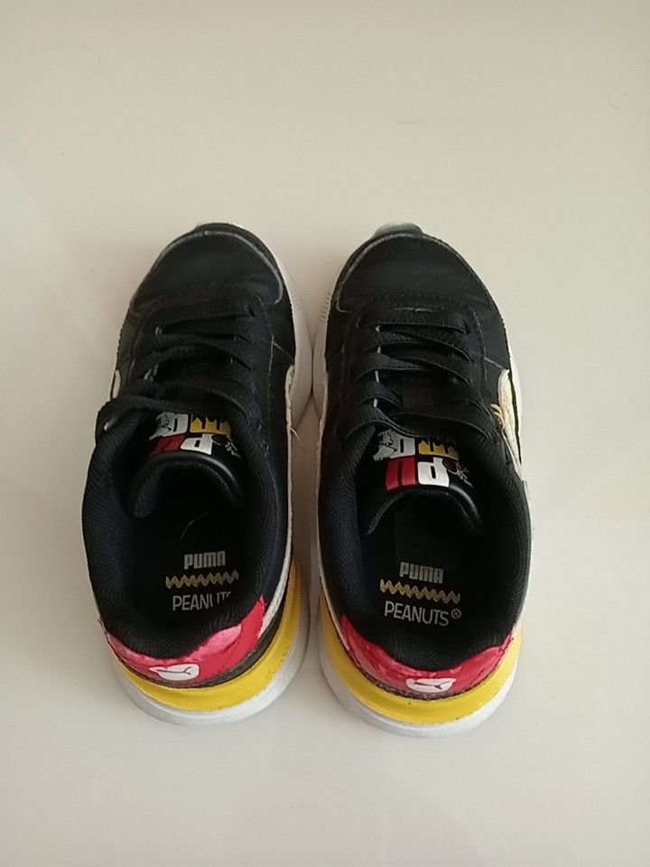 Puma x Peanuts Black Sneakers (Category: Babies & Kids Fashion) located in Singapore. Submitted by busy4nothing (Listing ID 1375314180, Image 1). Description: Check out these Puma x Peanuts sneakers! They've been worn a lot times, so there's some wear and tear, especially around the edges, but overall, they're still in good shape. The Snoopy design is super cute, and the colors are vibrant. The soles look pretty good too, with some minor wear. Th