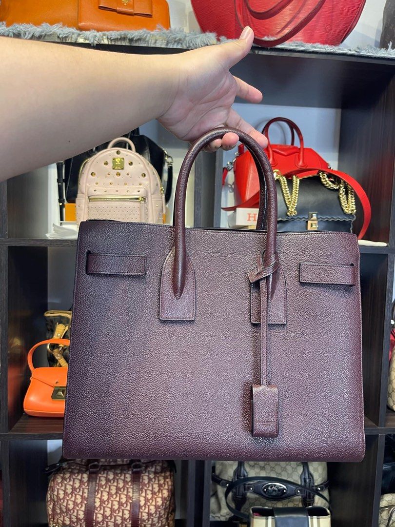 YSL sac de jour (Category: Luxury Bags & Wallets) located in Manila. Submitted by gracieler34184 (Listing ID 1375288917, Image 1). Description: Designer: Yves Saint Laurent Material: Burgundy grained leather Includes: Detachable strap, leather clochette with padlock, two keys, Origin: Italy Production Year: 2016 Date/Authenticity Code: GNR378299-0416 Measurements: 12.5” L x 6” W x 10” H Interior Pockets: One middle zip compartment, one zip pocket