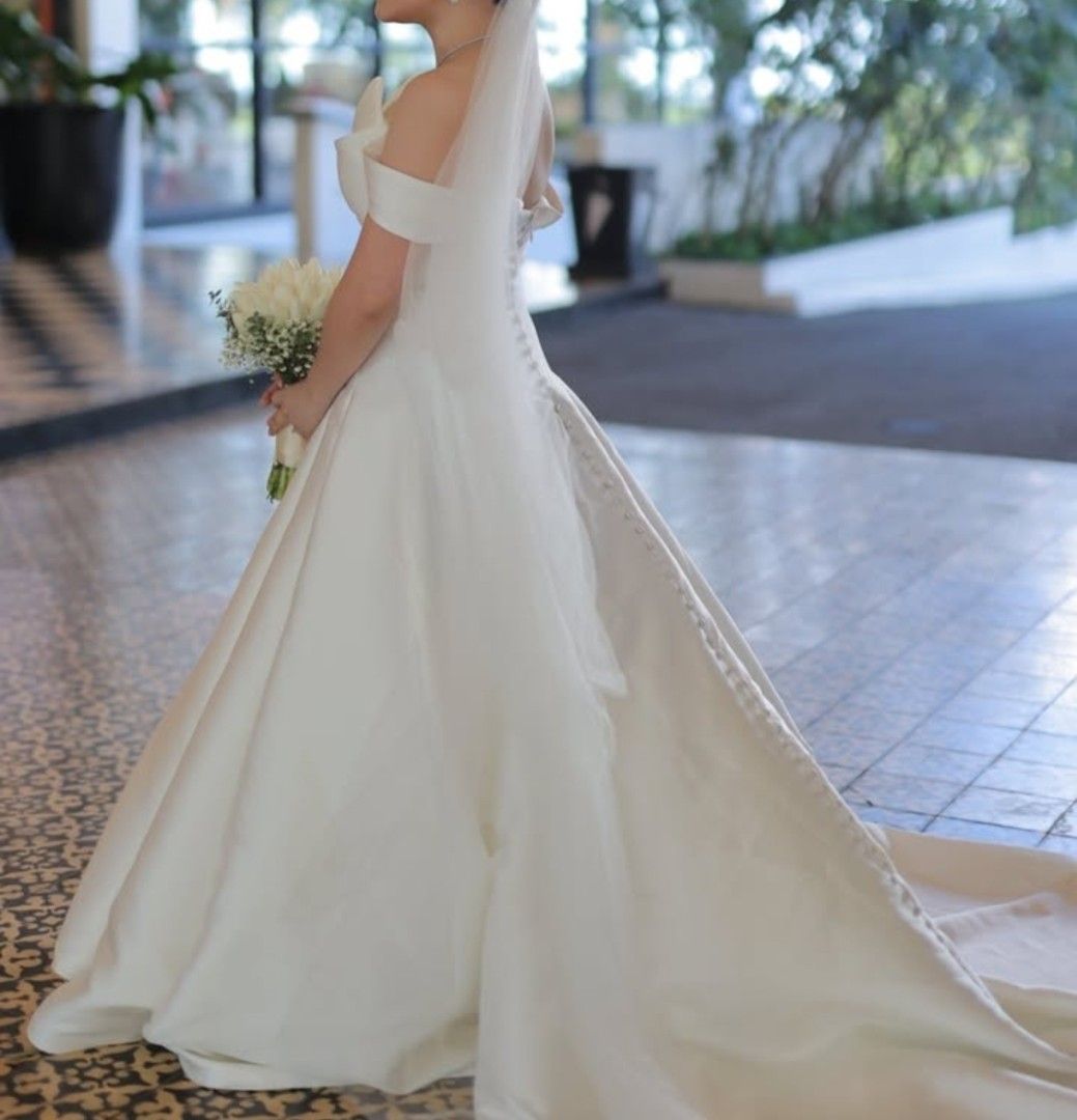 Ivory & White Wedding Gown (Daphne) (Category: Evening dresses & gowns) located in Makati City. Submitted by ClothesAndStuff (Listing ID 1372607365, Image 3). Description: Customized Daphne Bridal Gown Original Value: PHP 53,000 Description: This timeless and elegant ivory bridal gown, crafted from premium Duchess Satin, exudes sophistication and grace. This minimalist design is elevated by a stunning silver glass crystal belt and a full-covered 