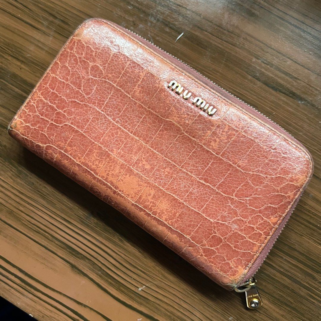 Miu Miu Leather Wallet (Category: Luxury Bags & Wallets) located in Binan City. Submitted by wordlywardrobe (Listing ID 1372530511, Image 1). Description: Original Miu Miu bought from Japan. Inside is still in great condition, some flaws outside hence the price. A cute salmon pink brown color with crocodile / alligator patent leather accent. Super cool find! .