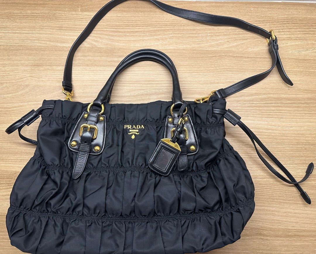 Authentic PR*DA Tessuto Gaufre (Category: Luxury Bags & Wallets) located in Pasig City. Submitted by luckybunch (Listing ID 1375912856, Image 2). Description: ✨ Prada Tessuto Gaufre Ruched Nylon Bag – Black ✨ Classic and timeless Prada piece from 2010 💼 Lightweight, spacious, and perfect for everyday use 🖤 Details: • Authentic Prada Tessuto Gaufre nylon • Color: Nero (black) with gold hardware • Comes with original card + dust bag • With detach