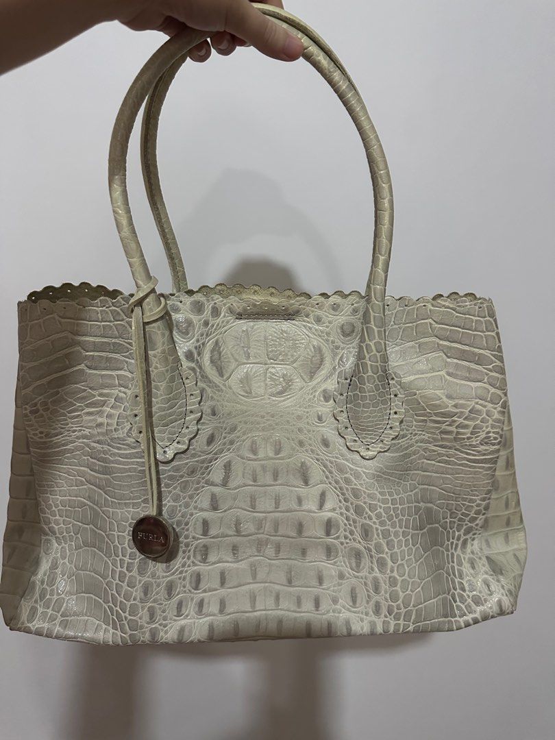 Furla crocodile leather embossed tote bag (Category: Luxury Bags & Wallets) located in Manila. Submitted by onestopboutique (Listing ID 1373997291, Image 1). Description: •100% Authentic •With dust bag •High in appeal and style •This tote from Furla comes crafted from croc-embossed leather and is equipped with dual top handles •An attached brand tag, and gold-tone hardware •The interior is fabric-lined and sized well to hold all your essentials. 