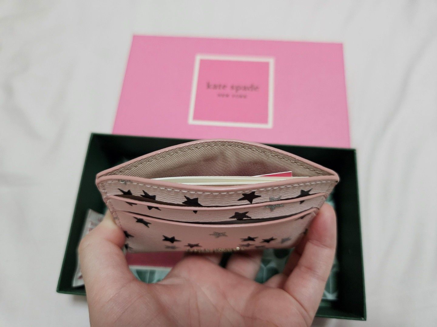 (Fast deal $70) Kate Spade Pink Star Card Holder (Category: Garage sale) located in Singapore. Submitted by roseate.love (Listing ID 1375965319, Image 3). Description: Kate Spade card holder. Pink with black and silver stars. Includes multiple card slots. Comes with original box. Compact and stylish..
