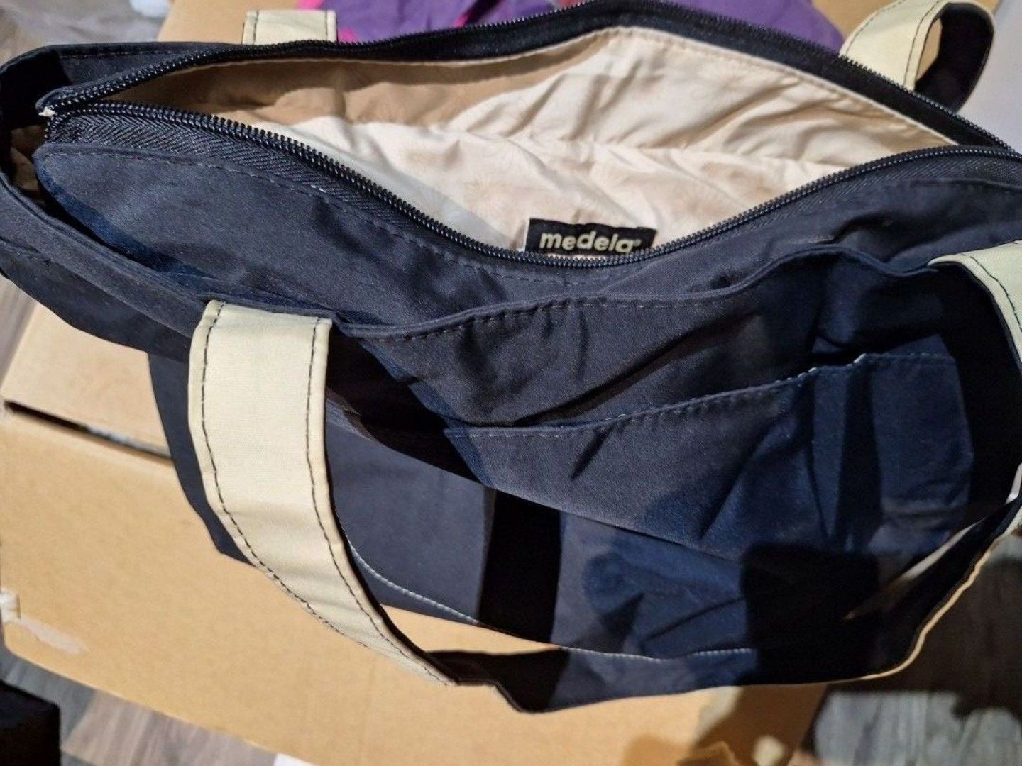 Medela Nursing Tote Bag (Category: Breastfeeding & Bottle Feeding) located in Singapore. Submitted by ja0000 (Listing ID 1375956035, Image 1). Description: Medela navy blue nursing tote bag. Features zipper closure, multiple pockets, and spacious main compartment. Perfect for baby essentials. slight defect with zip handle but can replace with keychain. .