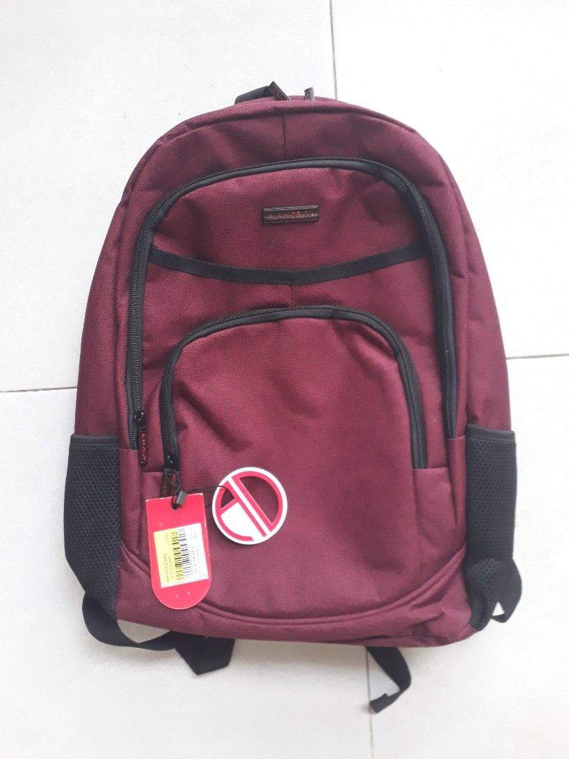 Alain Delon Maroon Backpack (Category: Bags & Wallets) located in Singapore. Submitted by tomtec70 (Listing ID 1376106215, Image 1). Description: Received as gift but i already have a backpack. Nice maroon colour with 3 zip pockets and 3 side pouches. Cushion back with comfortable shoulder straps and holder to secure your backpack to luggage handle when extended. Stylish and professional. Selling in Isetan for $79.90 Self collect in Sengkang unde