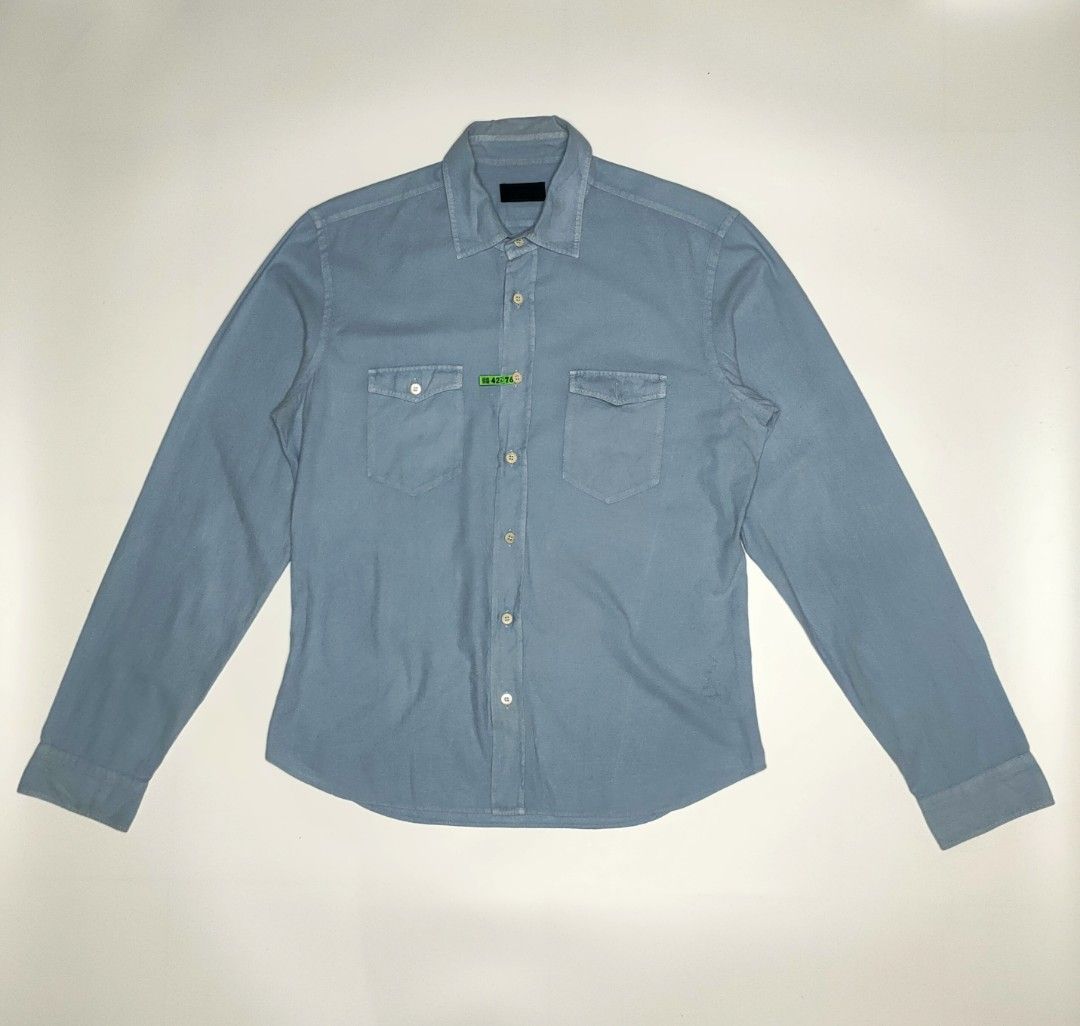 Prada Western-Style Denim Shirt (Category: Coats, Jackets and Outerwear) located in Manila. Submitted by 1702finest (Listing ID 1376153474, Image 1). Description: Prada Western-Style Denim Shirt Light blue snap-button shirt featuring dual chest pockets and subtle Prada tag detail on the placket. Measurements (inches): Fits Medium Pit to pit: 21 Shoulder: 18 Length: 28.5 Sleeve: 27 Hem: 21 Made in Italy. 🔸 Note: Minor stain on the right shoulder 