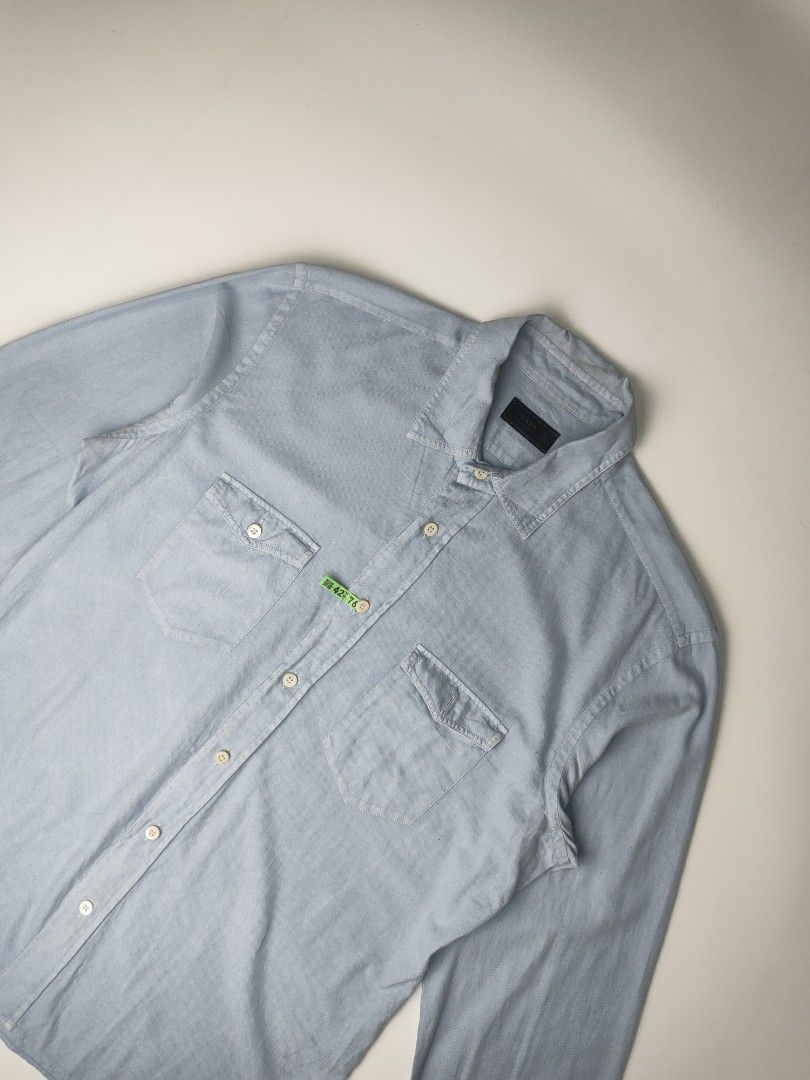 Prada Western-Style Denim Shirt (Category: Coats, Jackets and Outerwear) located in Manila. Submitted by 1702finest (Listing ID 1376153474, Image 2). Description: Prada Western-Style Denim Shirt Light blue snap-button shirt featuring dual chest pockets and subtle Prada tag detail on the placket. Measurements (inches): Fits Medium Pit to pit: 21 Shoulder: 18 Length: 28.5 Sleeve: 27 Hem: 21 Made in Italy. 🔸 Note: Minor stain on the right shoulder 