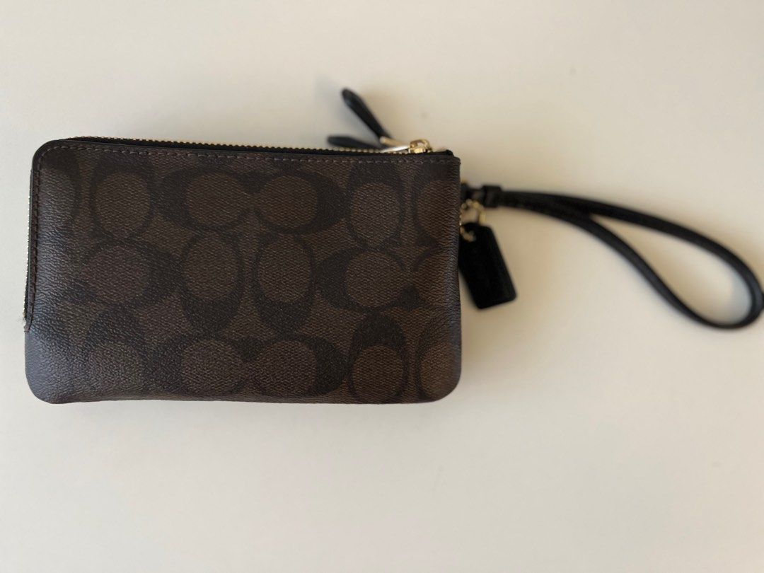 Coach Double Zip Wristlet Brown (Category: Bags & Wallets) located in Singapore. Submitted by likemegetme (Listing ID 1376297759, Image 2). Description: Double zip wristlet with a wrist strap. Features the iconic Coach logo. The interior has two compartments. Gold-tone hardware. Compact and stylish, perfect for everyday use. .
