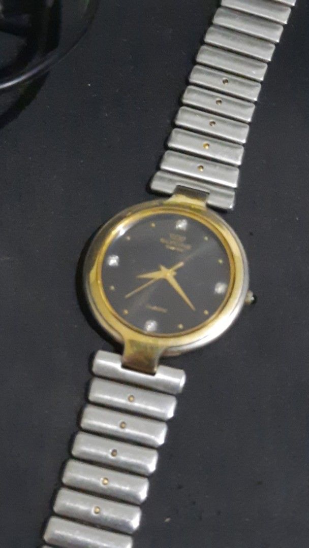 Glycine Swiss quartz (Category: Men's Watches) located in Bacolod City. Submitted by valuabletime79 (Listing ID 1376360302, Image 1). Description: The Glycine Swiss Quartz has a gold bezel, a black dial, and a silver band. It features four diamond markers and gold hands. The watch is a vintage model. All original.