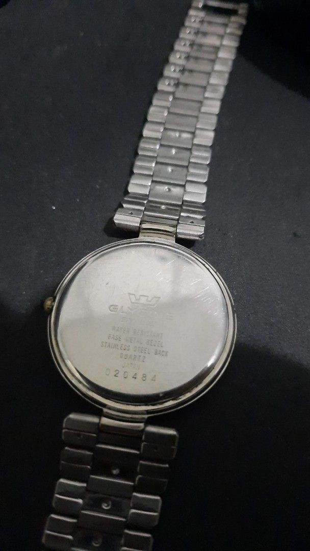 Glycine Swiss quartz (Category: Men's Watches) located in Bacolod City. Submitted by valuabletime79 (Listing ID 1376360302, Image 2). Description: The Glycine Swiss Quartz has a gold bezel, a black dial, and a silver band. It features four diamond markers and gold hands. The watch is a vintage model. All original.