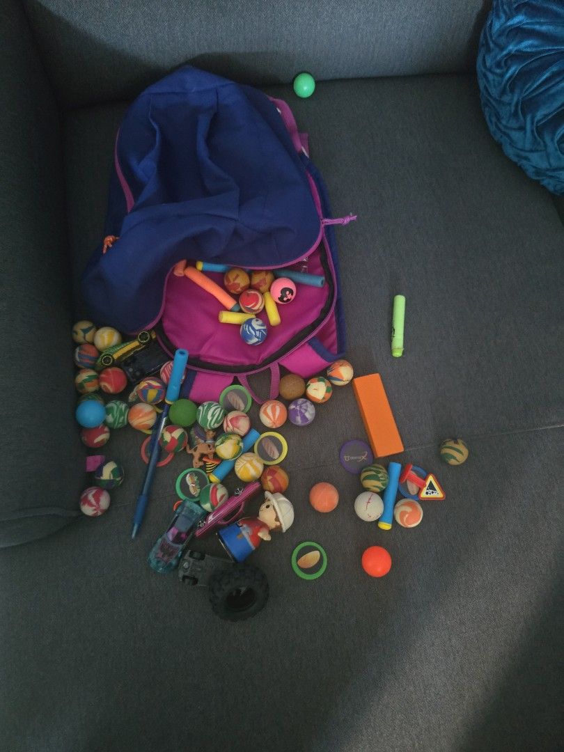 Rubber balls (Category: Babies & Kids Fashion) located in Singapore. Submitted by mabi53683 (Listing ID 1376268072, Image 1). Description: Children's blue and purple backpack filled with toys. Includes balls, projectiles, and a figurine. Perfect for imaginative play! $1 for all the rubber balls.