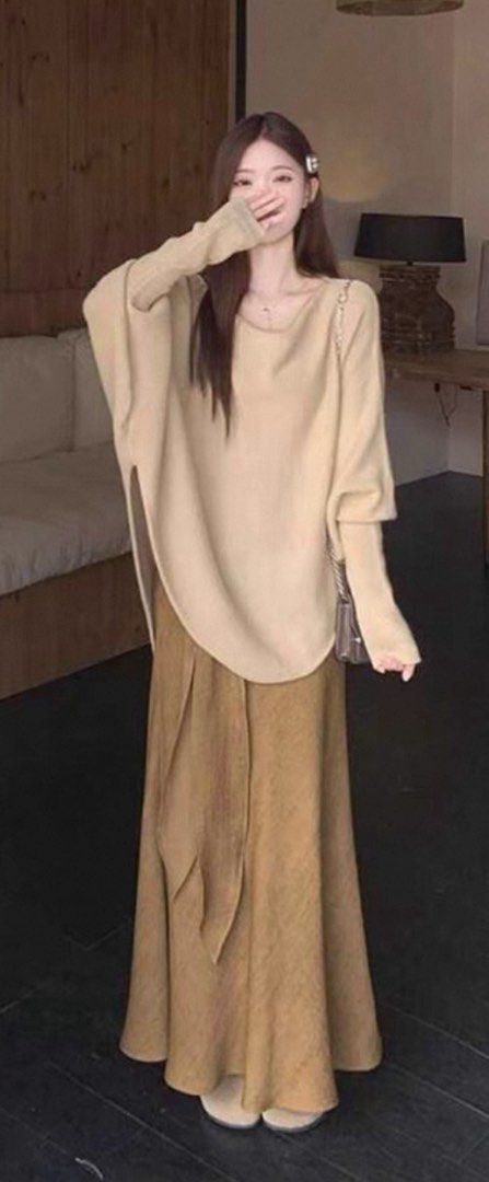 Bat Sleeve Top and Ribbon Tencel Linen A-Line Fishtail Skirt (Category: Blouses) located in Singapore. Submitted by discountdazzle (Listing ID 1376448958, Image 1). Description: This is a beige batwing top. It has a unique shape with a wide body and long sleeves. The top is laid out on a wooden floor. It looks like it could be a comfortable and stylish addition to your wardrobe. The color is neutral, making it easy to pair with different bottoms.