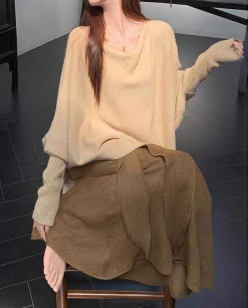 Bat Sleeve Top and Ribbon Tencel Linen A-Line Fishtail Skirt (Category: Blouses) located in Singapore. Submitted by discountdazzle (Listing ID 1376448958, Image 3). Description: This is a beige batwing top. It has a unique shape with a wide body and long sleeves. The top is laid out on a wooden floor. It looks like it could be a comfortable and stylish addition to your wardrobe. The color is neutral, making it easy to pair with different bottoms.
