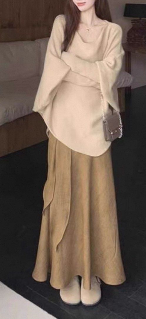 Bat Sleeve Top and Ribbon Tencel Linen A-Line Fishtail Skirt (Category: Blouses) located in Singapore. Submitted by discountdazzle (Listing ID 1376448958, Image 2). Description: This is a beige batwing top. It has a unique shape with a wide body and long sleeves. The top is laid out on a wooden floor. It looks like it could be a comfortable and stylish addition to your wardrobe. The color is neutral, making it easy to pair with different bottoms.