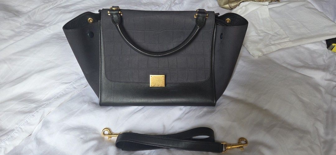 Celine Trapeze Medium Handbag (Category: Bags & Wallets) located in Singapore. Submitted by joanne123456 (Listing ID 1376503804, Image 2). Description: Celine Trapeze Medium handbag. Dark grey canvas and black leather. Top handle and detachable shoulder strap. Gold hardware. Structured silhouette with flap closure. not for fussy collection serangoon north Ave 1 or top up for courier.