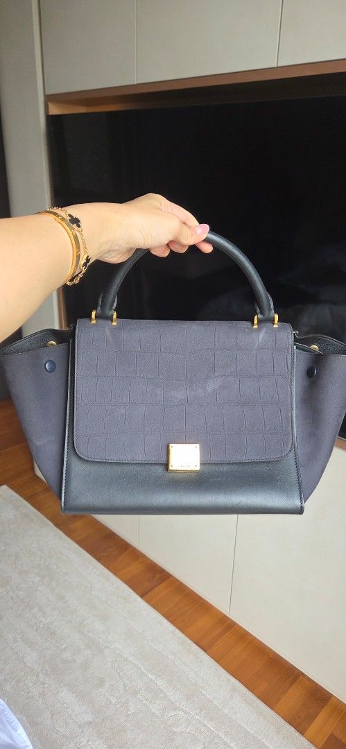 Celine Trapeze Medium Handbag (Category: Bags & Wallets) located in Singapore. Submitted by joanne123456 (Listing ID 1376503804, Image 1). Description: Celine Trapeze Medium handbag. Dark grey canvas and black leather. Top handle and detachable shoulder strap. Gold hardware. Structured silhouette with flap closure. not for fussy collection serangoon north Ave 1 or top up for courier.