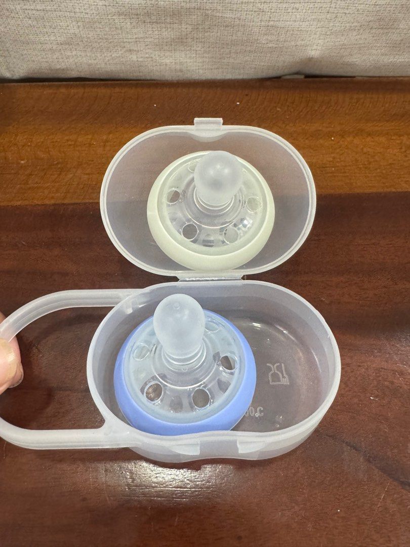 Tommee Tippee breast-like pacifier 0-6 months (Category: Soothers & Pacifiers) located in Antipolo. Submitted by jklmppage15 (Listing ID 1376591226, Image 2). Description: Gray one (glow in the dark) used only for a day to practice but baby never liked it (lahat ng babies ko ayaw sa pacifier). Blue one still brandnew. Comes with free case and holder..