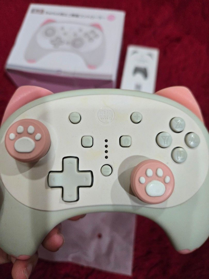 IINE Cat Controller (Category: Controllers) located in Putatan. Submitted by authel (Listing ID 1376733596, Image 2). Description: Includes: - Original box - Instruction manual - 2 pink paw thumbgrips - 🚫🙅‍♀️❌️ No wire!! (can use any type c wire cable to charge and connect to PC/Laptop) Connection: - Nintendo switch (wireless) - PC / Laptop (wired) Condition: Well used. Condition as in photos. can DM for more closeup photos..