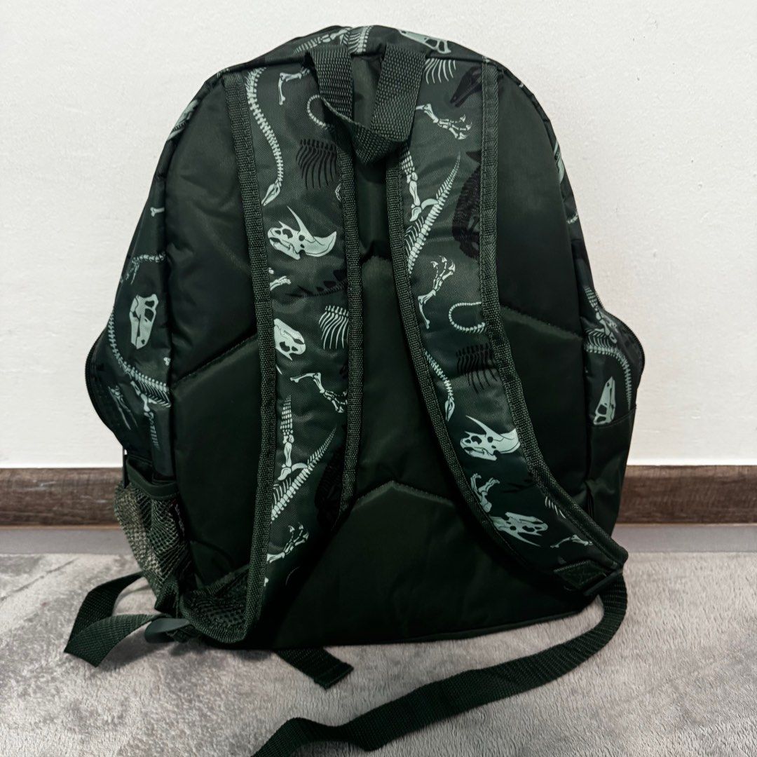 Smiggle Dinosaur Backpack (Category: Babies & Kids Fashion) located in Singapore. Submitted by northsider (Listing ID 1377093693, Image 3). Description: Smiggle backpack with a fun dinosaur skeleton print. Features multiple compartments for storage, including side mesh pockets. Adjustable straps for a comfortable fit. Perfect for school or travel. Used less than 5 times, almost new.