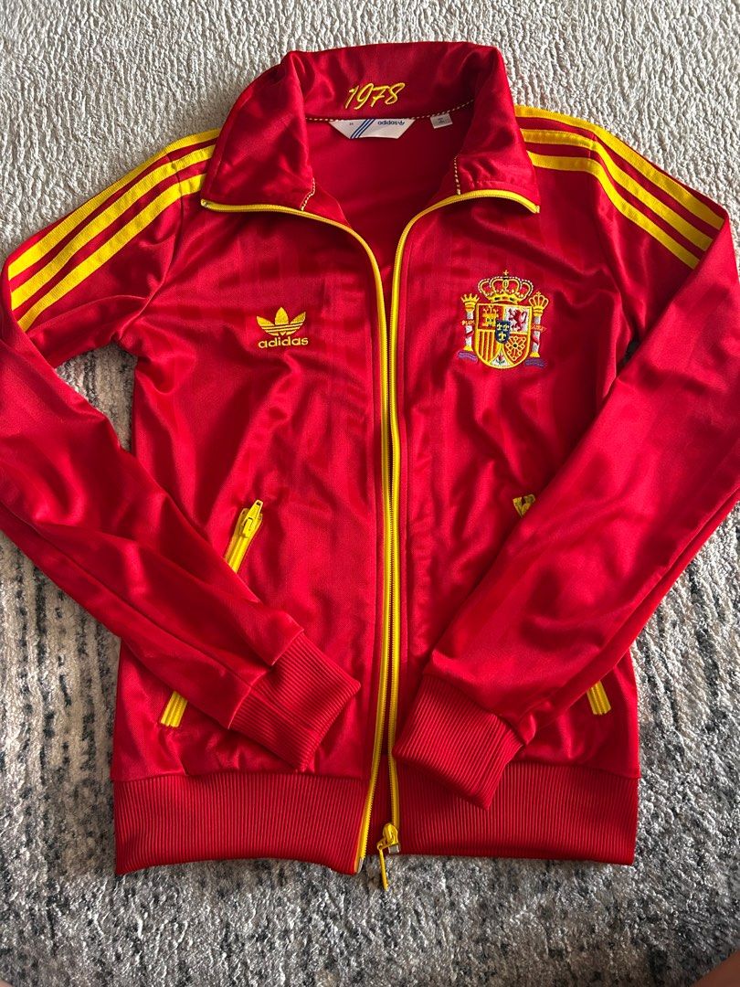 Adidas Spain Track Jacket - Vintage (Category: Coats, Jackets and Outerwear) located in Singapore. Submitted by melsmarket (Listing ID 1377228896, Image 2). Description: Vintage Adidas track jacket in excellent condition. Features the Spanish coat of arms and 'España' on the back. Includes yellow stripes and zippers. A stylish and classic piece for any fan..