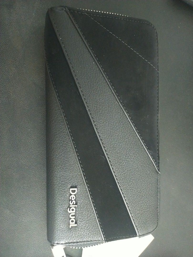 Desigual Black Zip Around Wallet (Category: Wallets & Card Holders) located in Singapore. Submitted by jojojo977 (Listing ID 1377248490, Image 1). Description: Black Desigual wallet with zip closure. Includes card slots, ID window, and unique textured design. Keeps essentials organized..