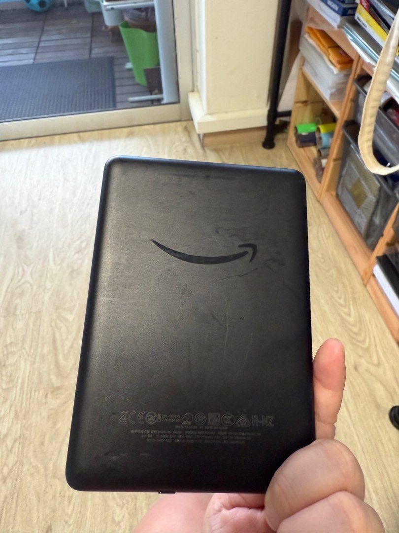 Amazon Kindle E-reader (Category: E-Readers) located in Singapore. Submitted by cangbello (Listing ID 1377528307, Image 2). Description: Used Amazon Kindle e-reader. Shows some signs of wear on the back. Screen is in good condition. Perfect for reading on the go. Comes with no accessories..