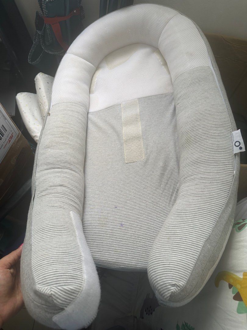 Baby Nest- sleep bed movable (Category: Cots & Cribs) located in Singapore. Submitted by nemi.7 (Listing ID 1377532286, Image 1). Description: Gently used baby nest in good condition. Features a soft, striped design with a comfortable headrest. Perfect for newborns and infants. Includes velcro straps for secure placement. Some minor stains are visible..