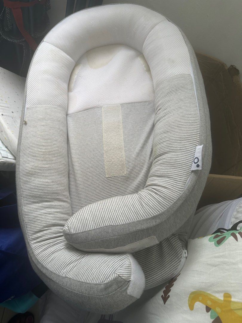 Baby Nest- sleep bed movable (Category: Cots & Cribs) located in Singapore. Submitted by nemi.7 (Listing ID 1377532286, Image 2). Description: Gently used baby nest in good condition. Features a soft, striped design with a comfortable headrest. Perfect for newborns and infants. Includes velcro straps for secure placement. Some minor stains are visible..