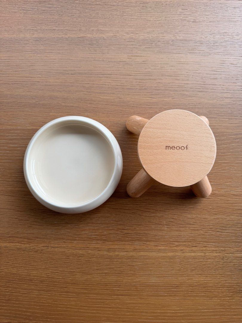 Meoof Elevated Ceramic Cat Food Bowl (Category: Homes & Other Pet Accessories) located in Singapore. Submitted by chua.minhan (Listing ID 1377476552, Image 3). Description: Stylish and functional Meeoof pet bowl. Elevated design with a ceramic bowl and wooden stand. The bowl is a cream color. The stand has the brand name 'meoof' engraved on it. Perfect for your furry friend!.