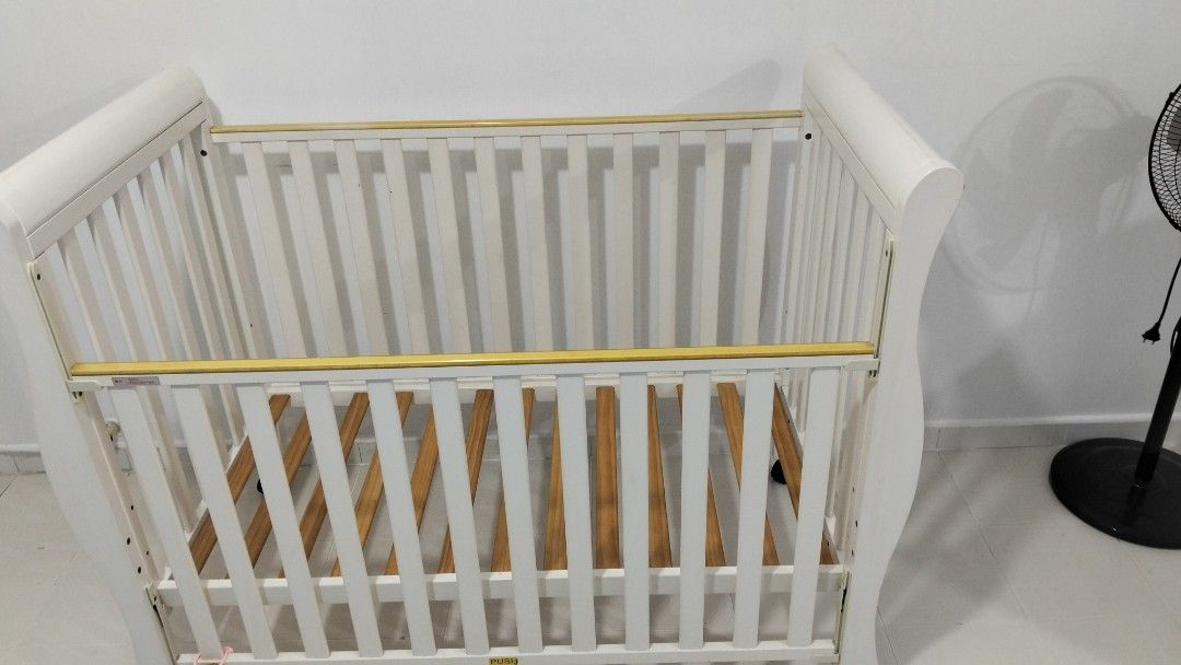 White Baby Cot with Wheels (Category: Cots & Cribs) located in Singapore. Submitted by metharita295178 (Listing ID 1377464532, Image 1). Description: - White baby cot - Wooden slats - Wheels for easy movement - Good condition - Suitable for newborns and young babies.