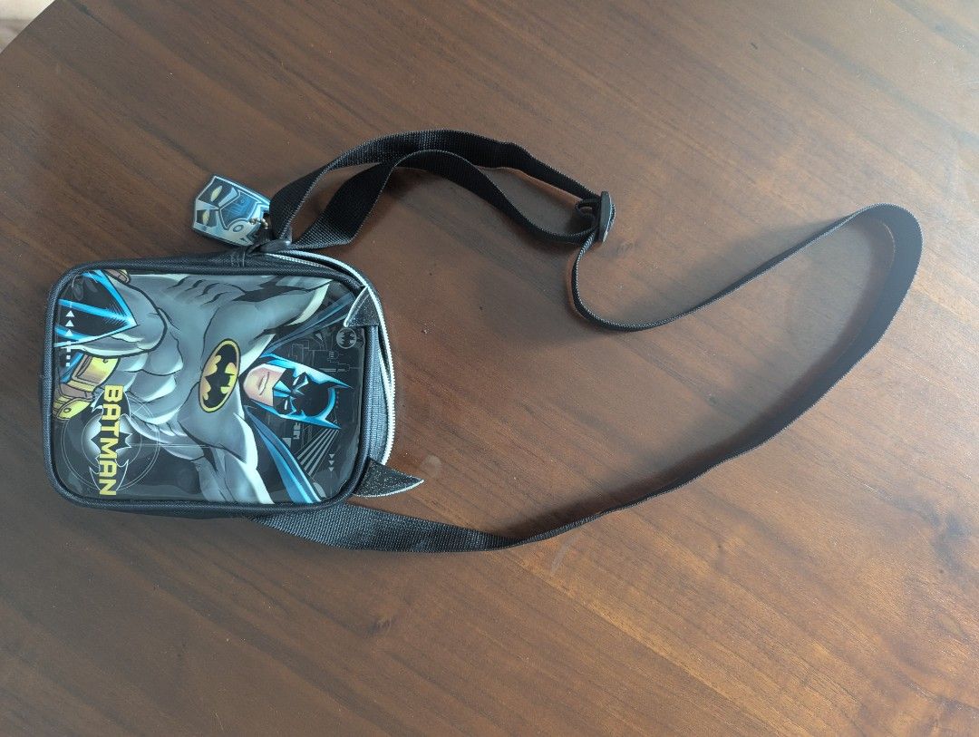 Batman Crossbody Bag (Category: Babies & Kids Fashion) located in Singapore. Submitted by audrey.wang.397501 (Listing ID 1377593586, Image 1). Description: - Batman crossbody bag - Features a cool Batman graphic - Includes a long strap for easy carrying - In great condition - Ideal for small items.