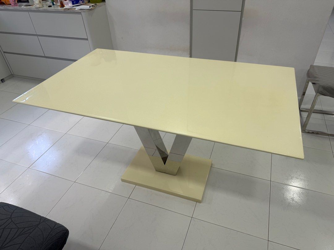 Cream Rectangular Dining Table (Category: Tables & Sets) located in Singapore. Submitted by purpurl (Listing ID 1377606556, Image 3). Description: Elegant rectangular dining table in cream color. Features a unique V-shaped stainless steel base. Table dimensions are approximately 140cm long and 80cm wide. Minor imperfections are visible, as shown in the photos. Price negotiable but not inclusive of delivery. Need to get ur own mover. Cash and carr